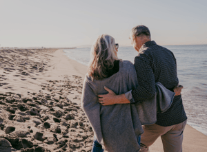 older-couple-walking-on-beach (1)
